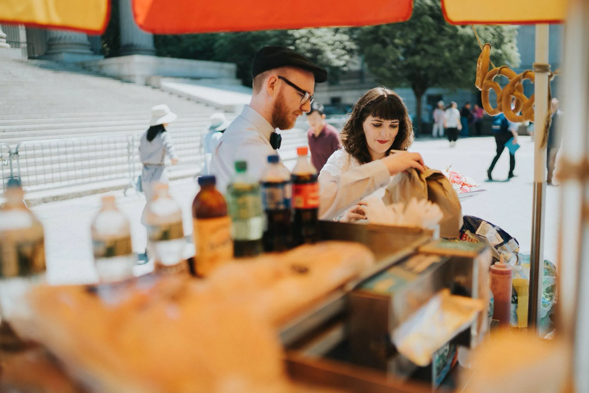 A couple browsing a street food stall together at their wedding.