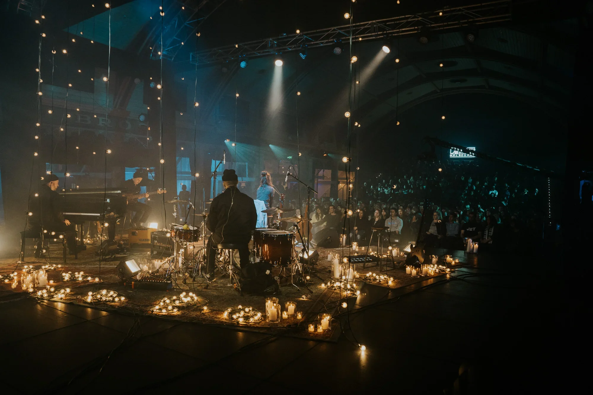 Sydney live music event photography: A band performing on a candlelit central stage for a seated audience.